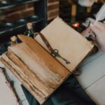 Close-up view of a vintage spell book with a quill and key in a fantasy setting.