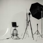 A black and white photo of a well-equipped photography studio with lighting equipment and tripods.
